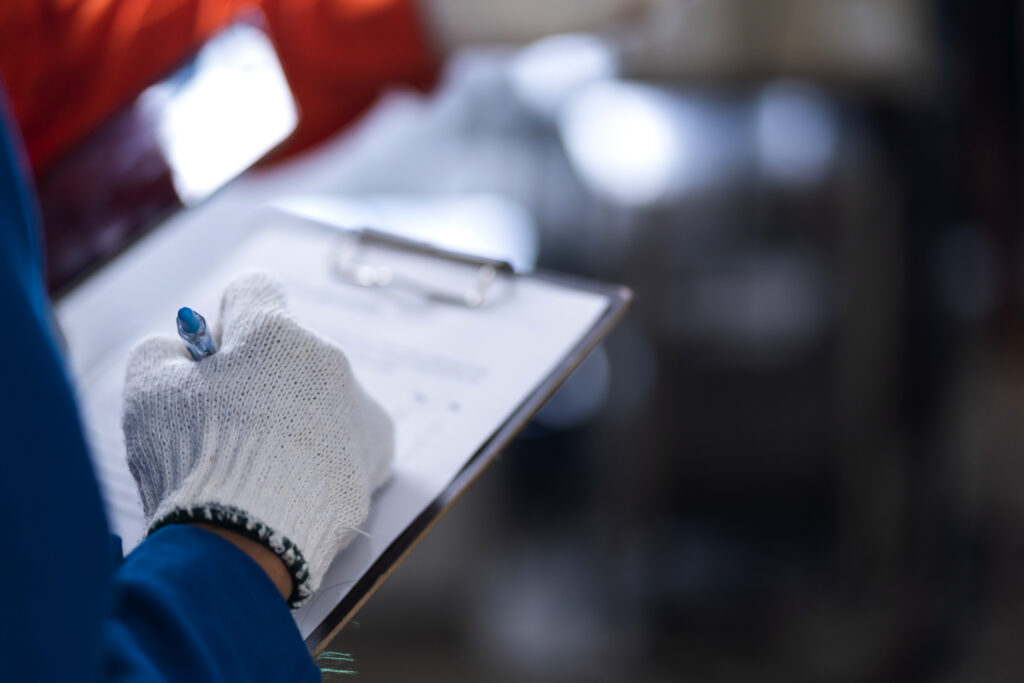 Profissional registrando uma inspeção técnica em prancheta
